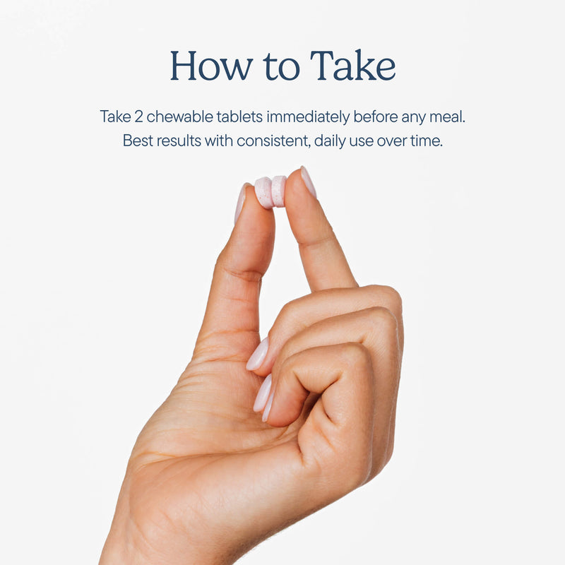 Hand holding two white chewable tablets between thumb and index finger, with dosage instructions above on light background